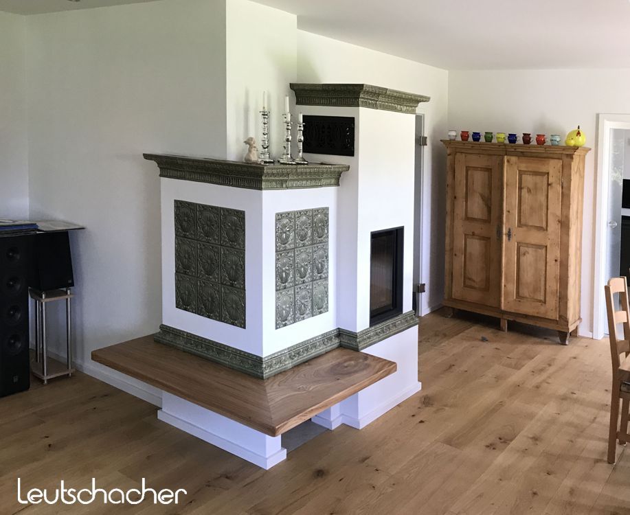 Verputzter Kachelofen mit Kacheln im Landhausstil Grün glasiert.